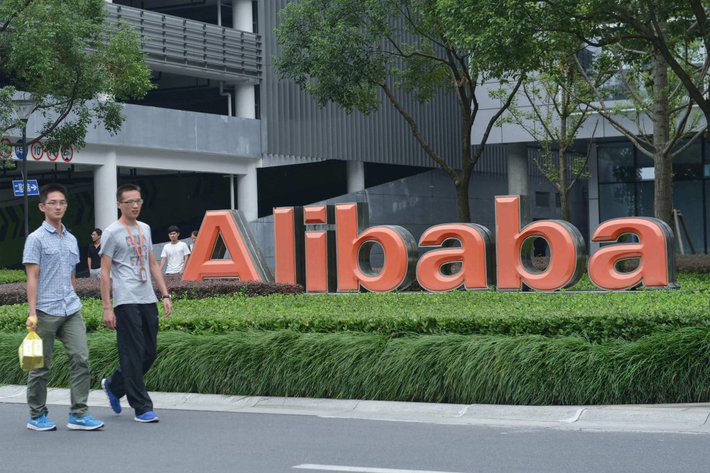 Staff members walk past the logo of Chinese e-commerce giant Alibaba at its headquarters in Hangzhou, in China’s eastern Zhejiang province. Photo: AFP