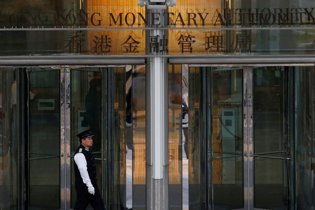 An attendant walks outside the entrance to Hong Kong Monetary Authority in Central. Photo: Reuters