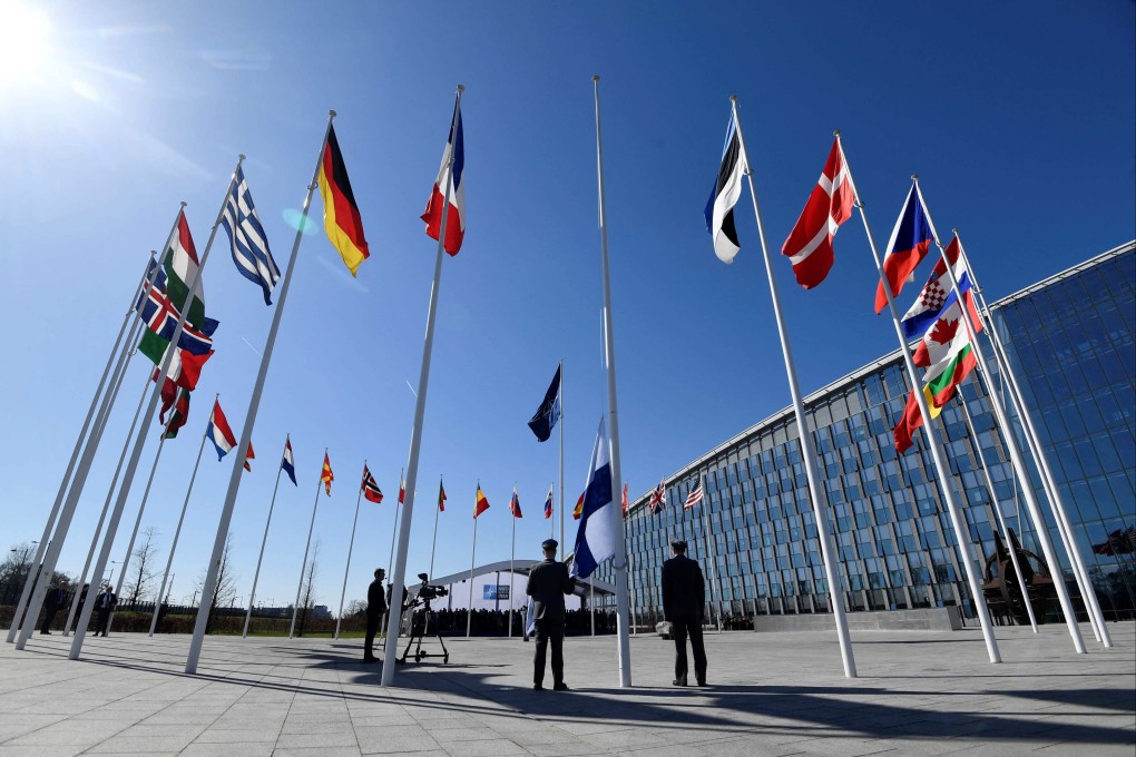 Finnish military personnel install their national flag at the Nato headquarters in Brussels on Tuesday. Photo: AFP