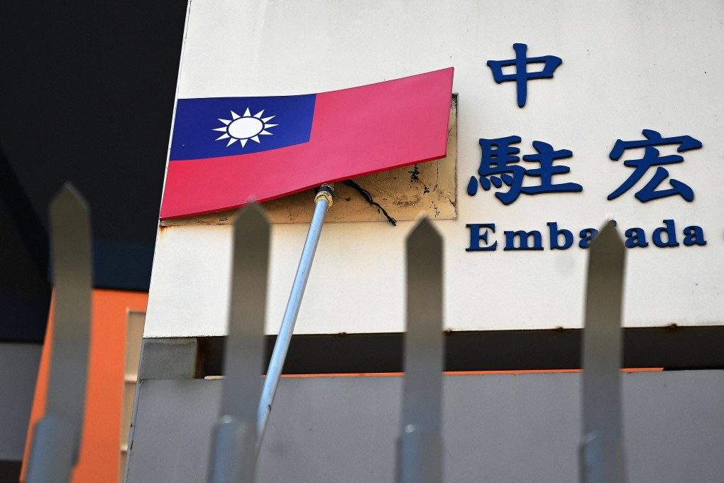 A worker takes down Taiwan’s flag from the facade of the embassy in Tegucigalpa, Honduras, on March 27. China and Honduras have announced the establishment of diplomatic relations. Photo: AFP