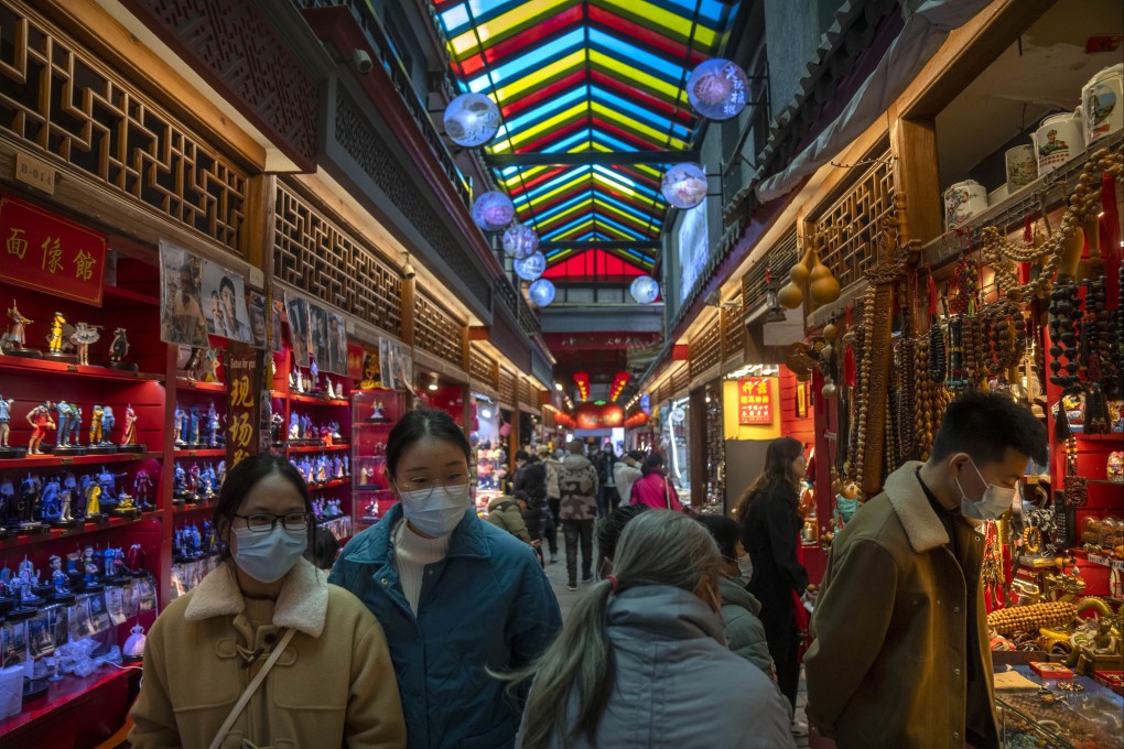 Visitors look at shops selling trinkets and souvenirs along a tourist shopping street in Beijing on February 28. China’s recovery is largely driven by a rebound in consumption and this counter-trend recovery can play a key role in supporting Asia’s growth. Photo: AP
