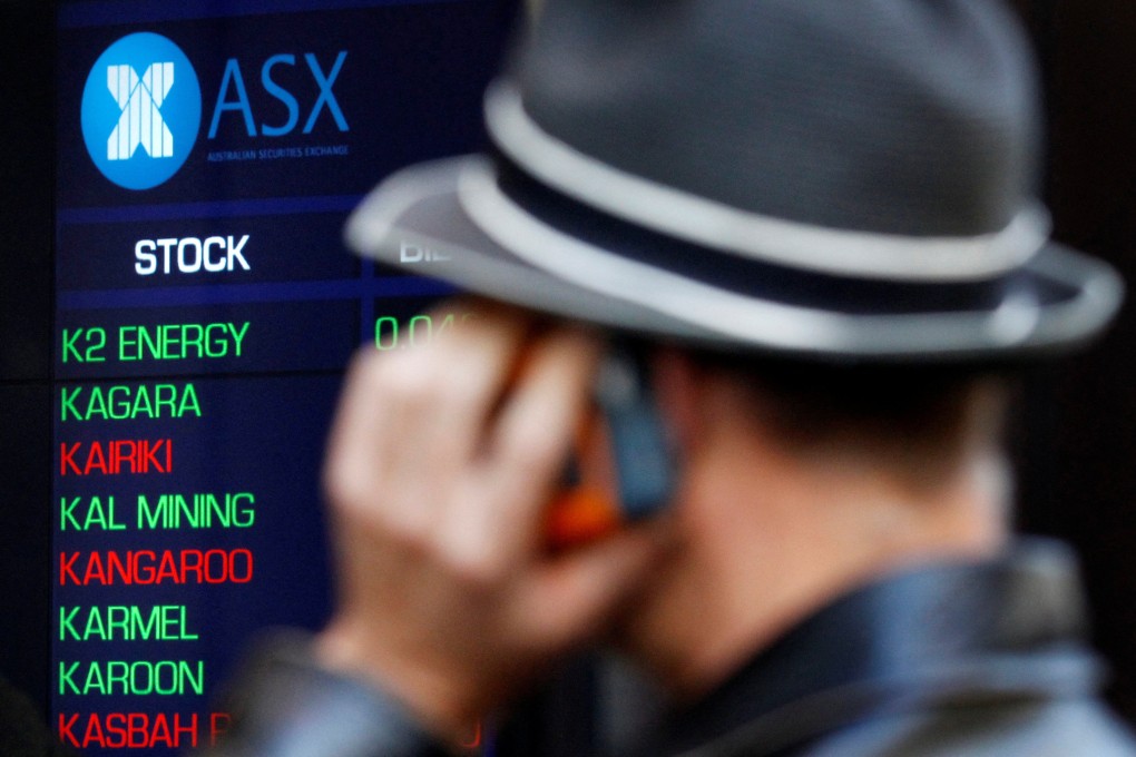 A man talks on a mobile phone while watching indicator boards at the Australian Stock Exchange in Sydney. Rising interest rates and inflation took a toll on equity markets globally last year. Photo: Reuters