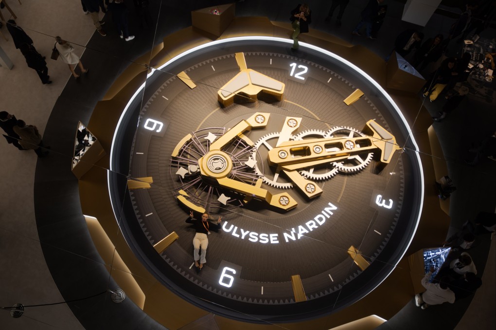 Visitor walks past a huge watch display at the Ulysse Nardin booth during the Watches and Wonders in Geneva, Switzerland, March 27, 2023. Photo: EPA-EFE