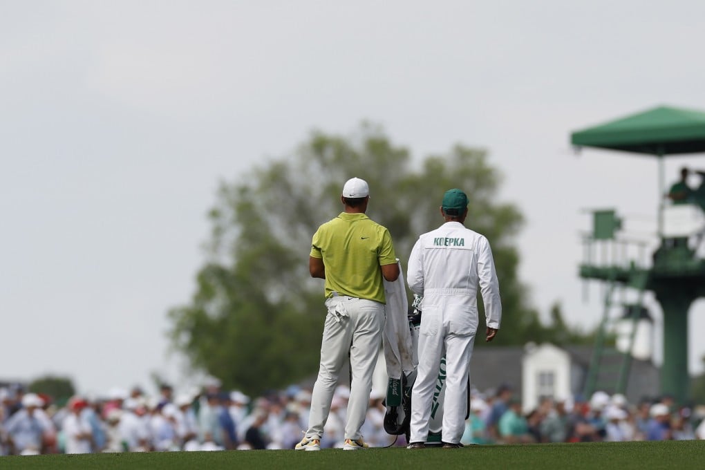 Brooks Koepka (left) and caddie Ricky Elliott stand on the 18th fairway during the first round of the Masters. Photo: EPA-EFE
