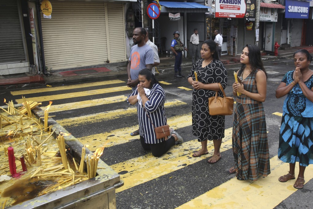Sri Lankans light candles and pray outside St. Anthony’s Church in Colombo on April 30, 2019. Photo: AP