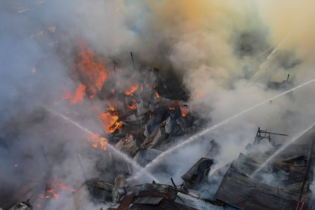 Firefighters battle flames after a fire broke out at a residential area in Manila in March. On Saturday, seven people died in another blaze. Photo: AFP
