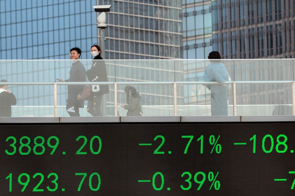 People cross the pedestrian bridge with a screen showing the latest stock exchange data in Lujiazui main financial district of Shanghai on March 16. Photo: EPA-EFE