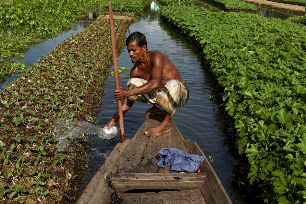 A farmer in the low-lying Pirojpur district of Bangladesh irrigates a floating bed at his farm in 2022. Bangladesh could lose more than a tenth of its land to sea level rise in two decades, with climate change bringing more extreme heat and rainfall. Photo: Reuters