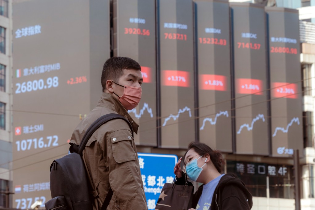 People walk on the street near a large screen showing the latest stock exchange data in Shanghai on March 15. Photo: EPA-EFE