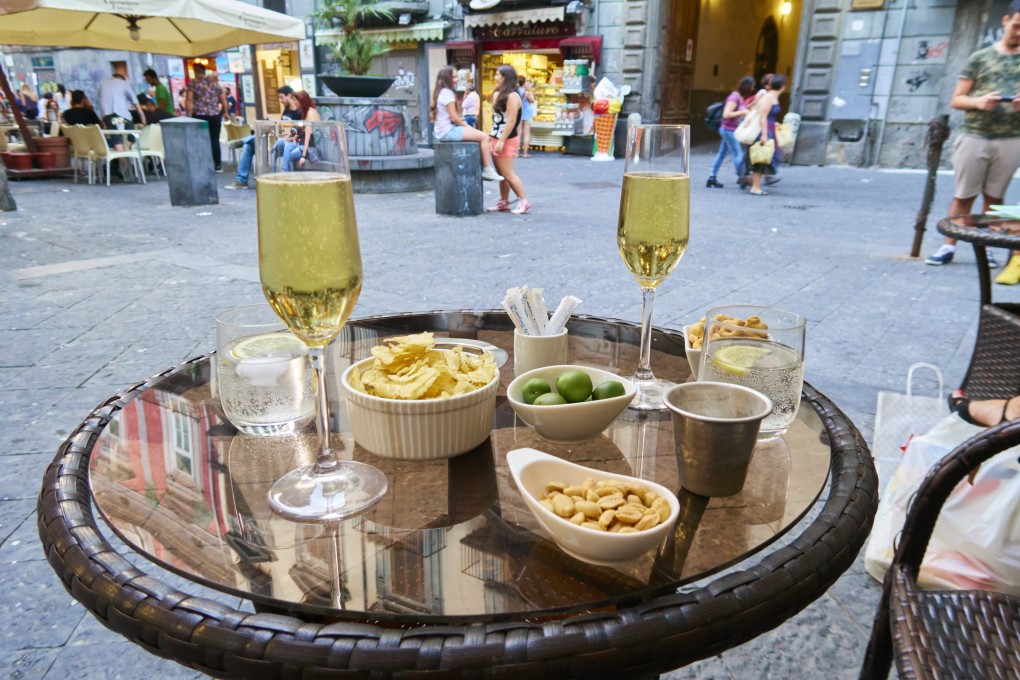Aperitivo in Naples, with two glasses of prosecco, olives and nuts. The Italian pre-dinner ritual has been around since Roman times and has since evolved into a global phenomenon. Photo: Getty Images