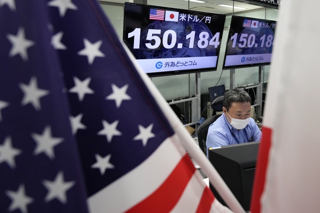 A dealer works as displays show the exchange rate between the Japanese yen and the US dollar at a foreign exchange trading company in Tokyo on October 21, 2022. Photo: EPA-EFE