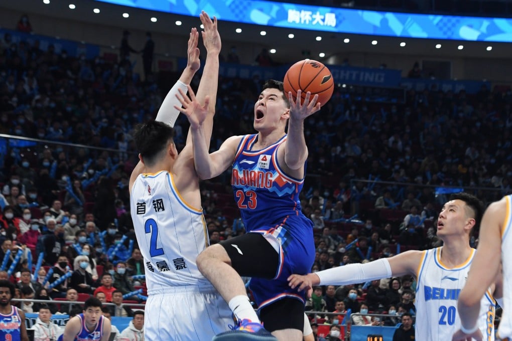 Abudushalamu Abudurexiti (centre) of Xinjiang Flying Tigers goes for a lay up during the 36th round match against the Beijing Ducks in Beijing on March 17. Photo: Xinhua