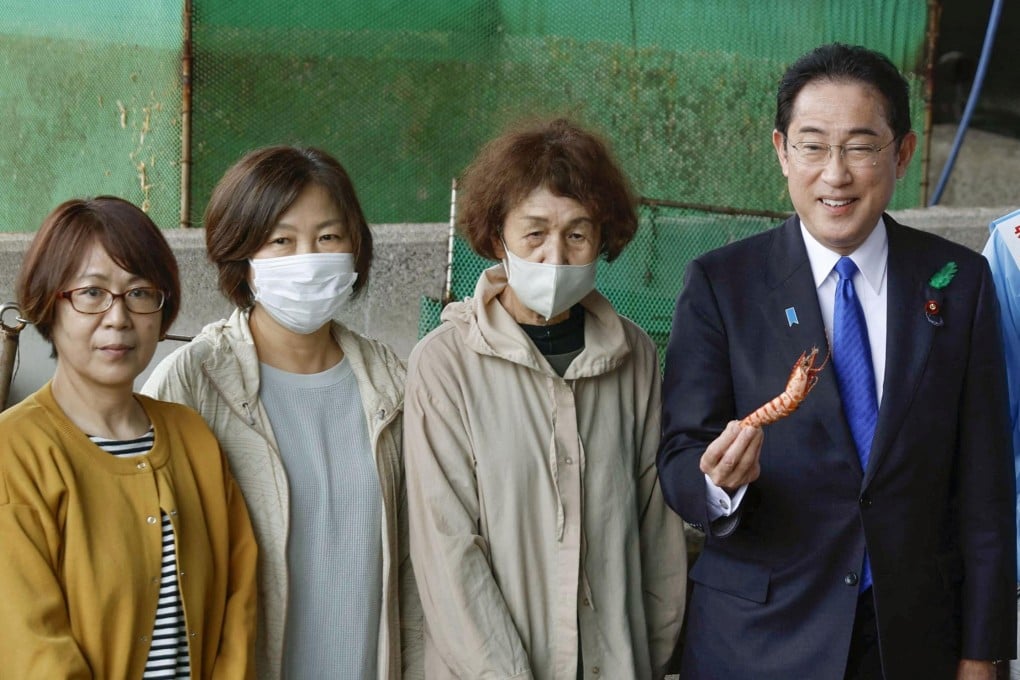Japanese Prime Minister Fumio Kishida tastes seafood during an election campaign event in Wakayama on Saturday. Photo: Kyodo via Reuters