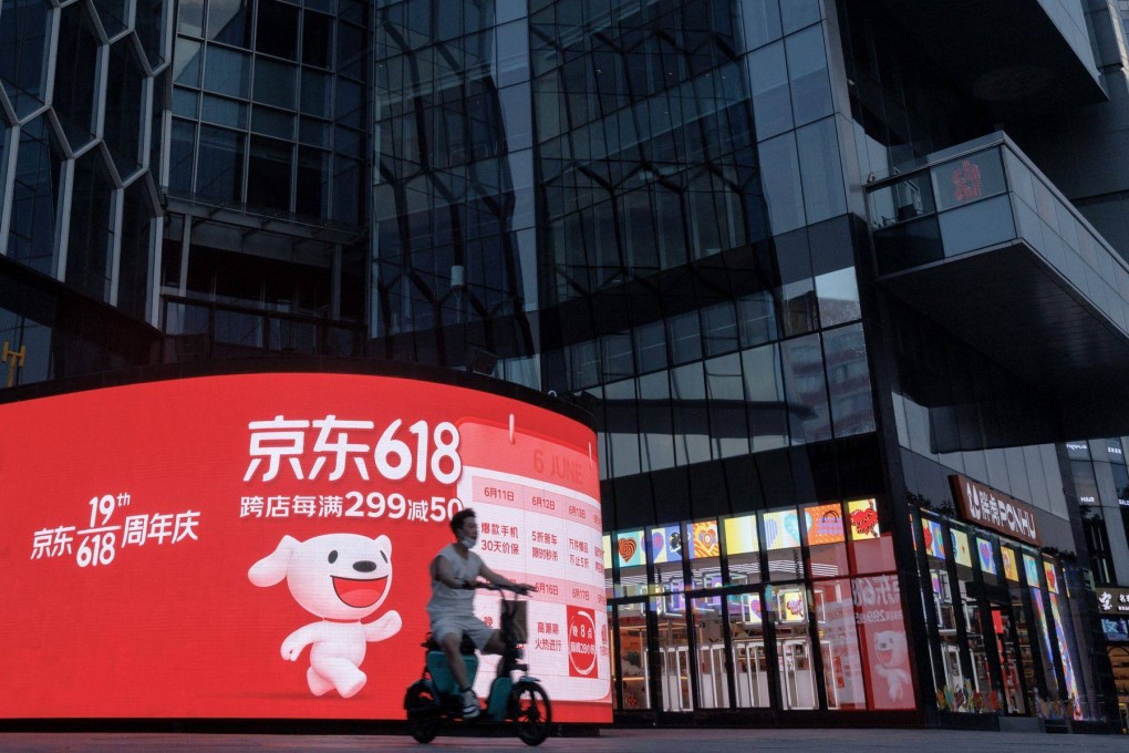 A person rides a scooter past a JD.com advertisement for the “618” shopping festival in Beijing in June 2022.Photo: Reuters