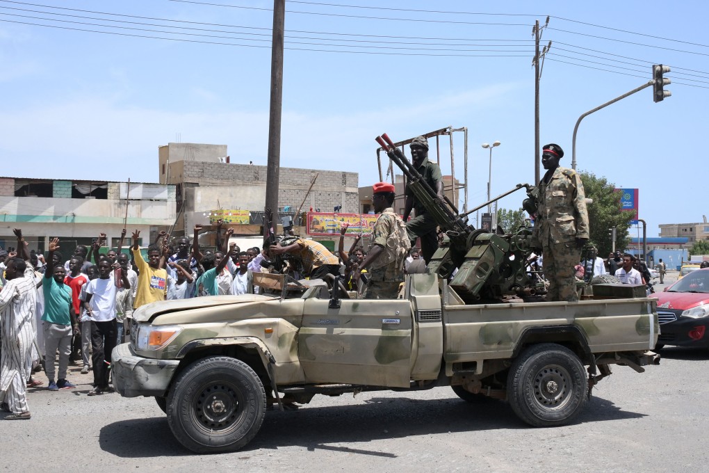Sudanese greet army soldiers, loyal to army chief Abdel Fattah al-Burhan, in the Red Sea city of Port Sudan on Sunday. Photo: AFP via Getty Images / TNS