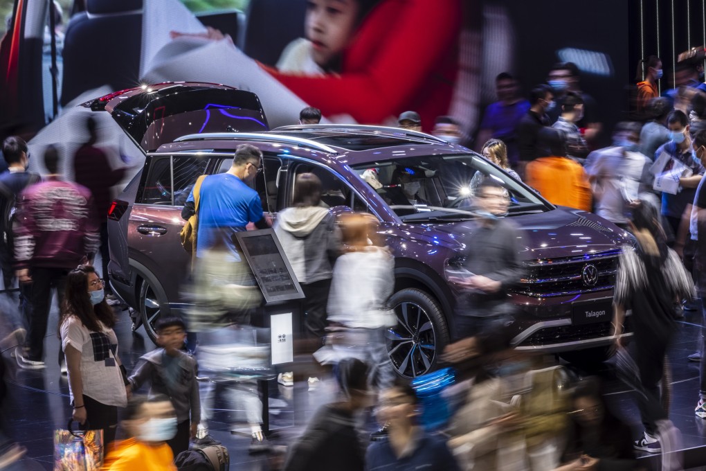 A long exposure photo shows people looking at cars on display during the Shanghai auto show in 2021. Photo: EPA-EFE