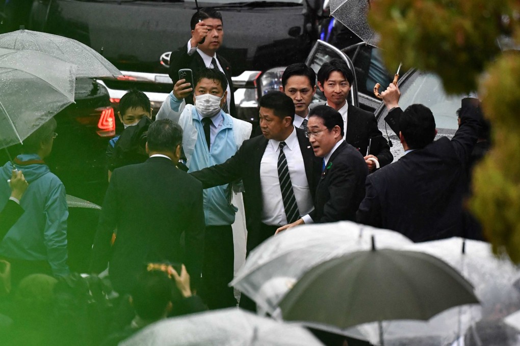 Japan’s Prime Minister Fumio Kishida is escorted by security officers at an election campaign event in Chiba prefecture on Saturday, hours after being evacuated unharmed from the scene of an apparent “smoke bomb” blast at another event earlier that day. Photo: AFP