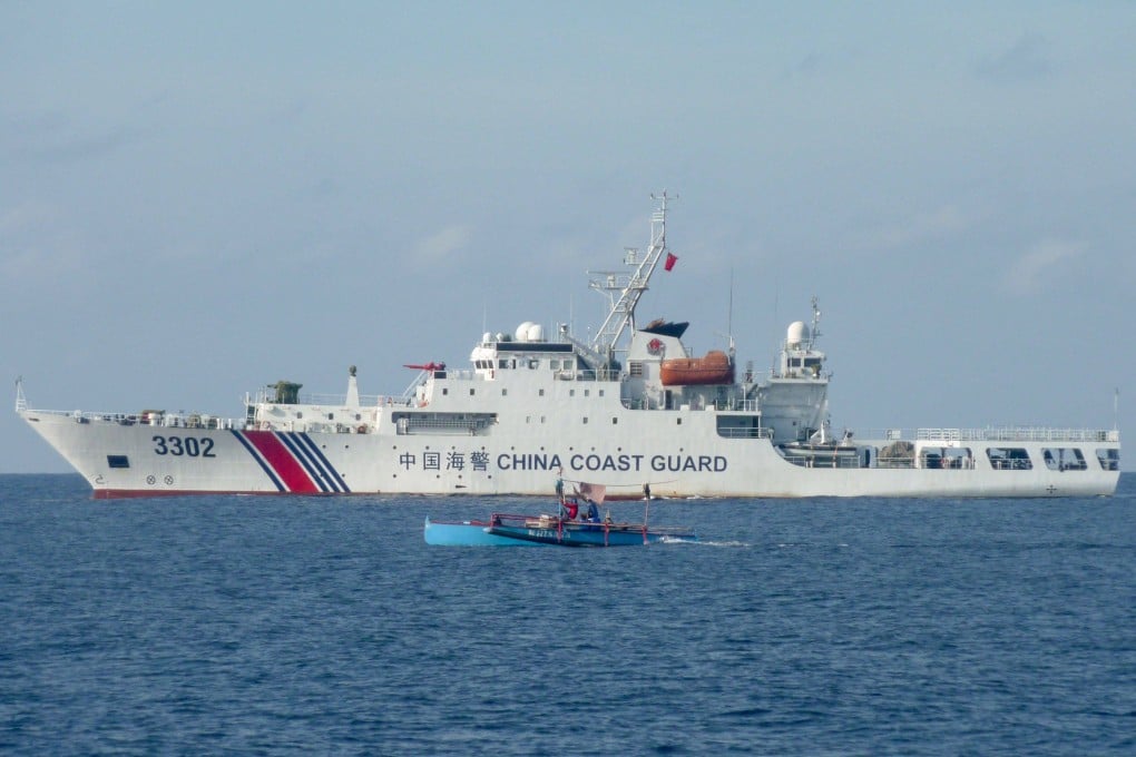 Filipino fishermen sail past a Chinese coastguard ship in the disputed Scarborough Shoal in the South China Sea in February. Photo: AFP