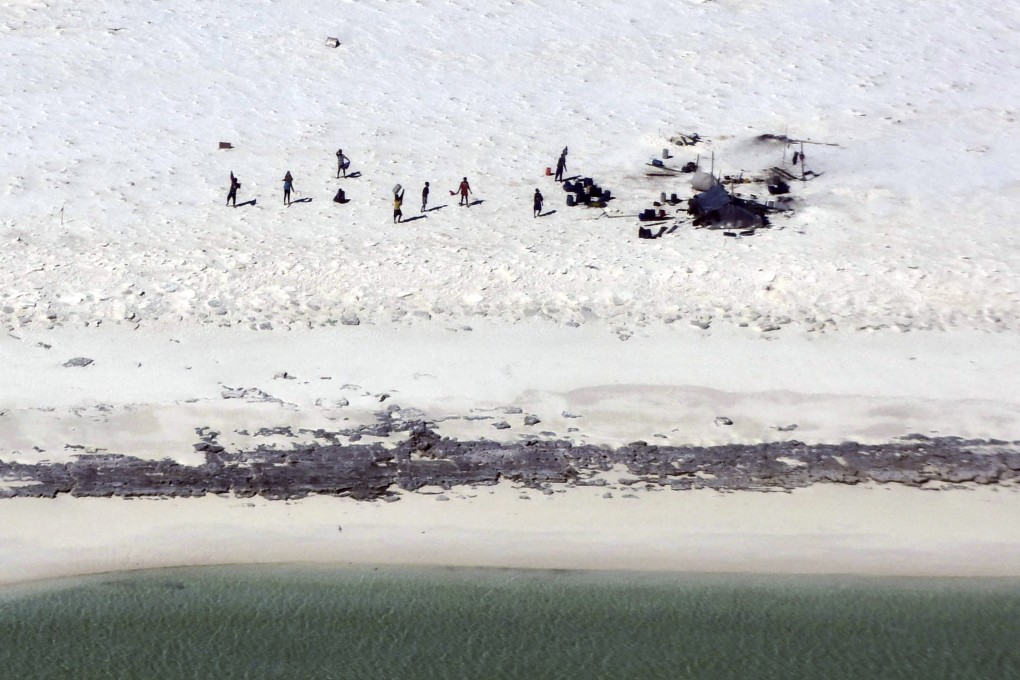 Fishermen from Indonesia stranded on Bedwell Islet, more than 300km off the coast of Australia, gesture towards a rescue aircraft on Monday. Photo: Australian Maritime Safety Authority via AP