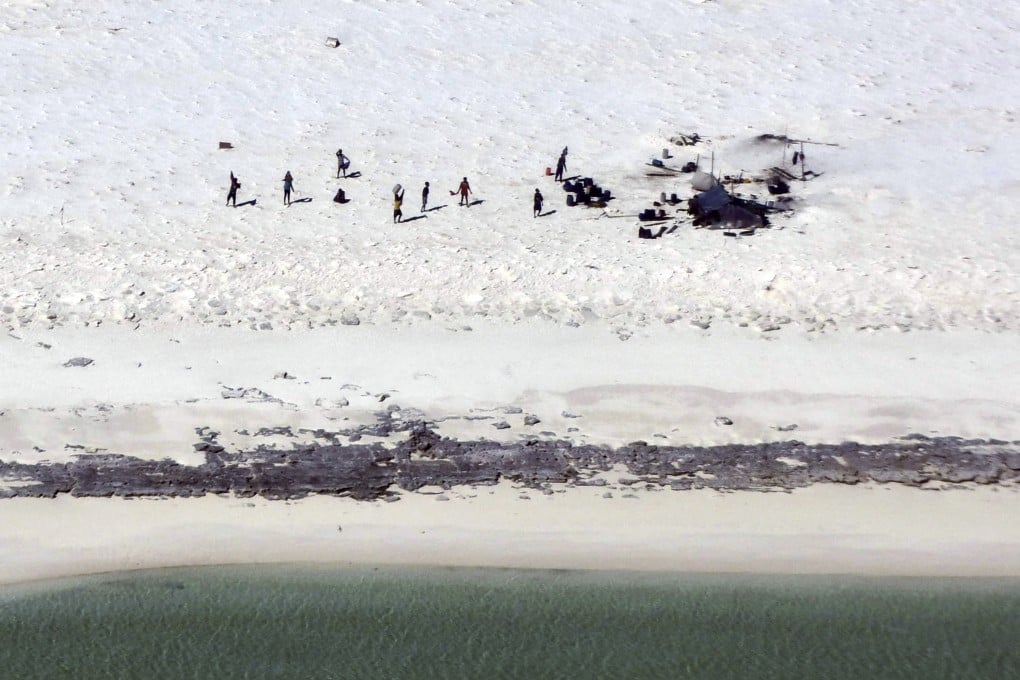 Fishermen from Indonesia stranded on Bedwell Islet, more than 300km off the coast of Australia, gesture towards a rescue aircraft on Monday. Photo: Australian Maritime Safety Authority via AP