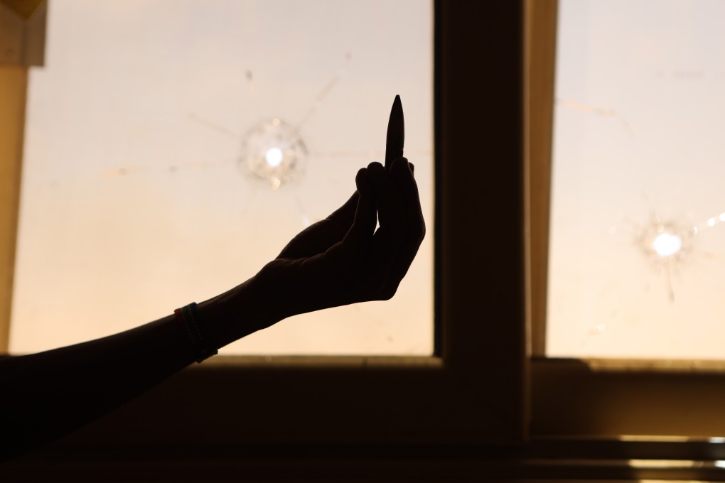 A civilian holds up an empty bullet case in front of a damaged window of a residential building during ongoing skirmish between the Sudanese army and paramilitary forces in Khartoum, Sudan on Tuesday. Photo: EPA-EFE