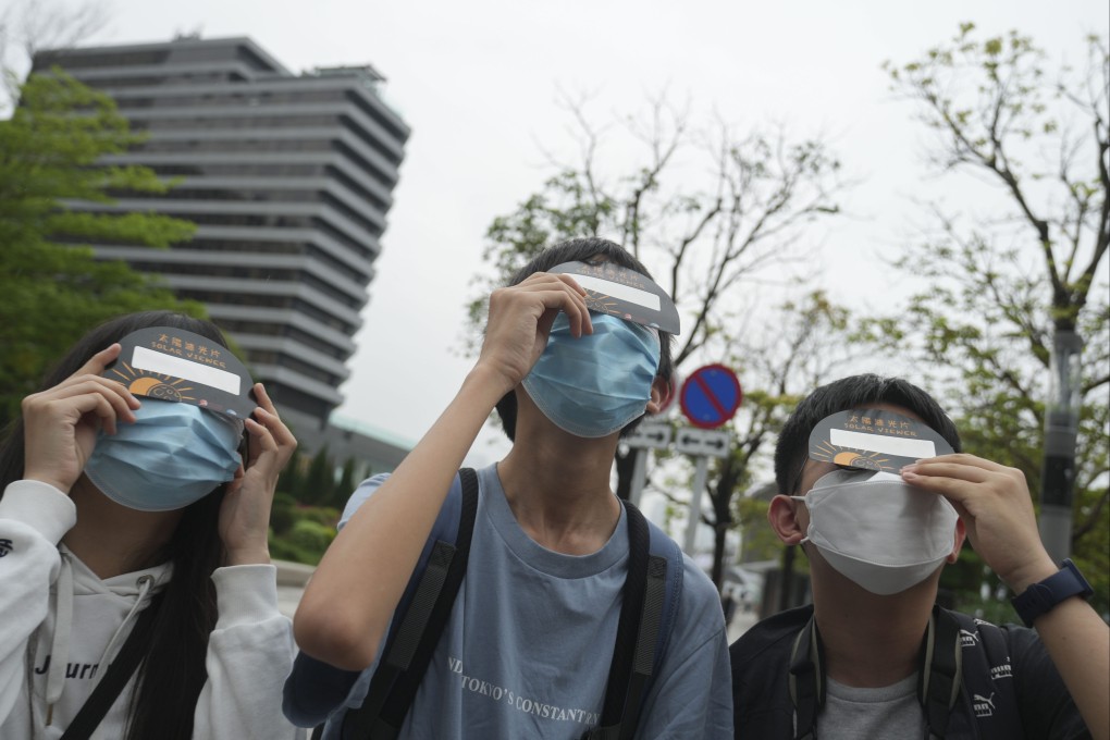 Residents try to catch a glimpse of Thursday’s partial eclipse. Photo: Sam Tsang