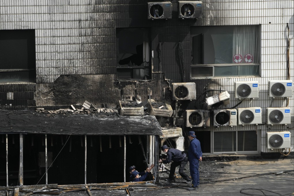 Investigators inspect a burnt-out section of a hospital where 29 people died in a blaze on Tuesday. Photo: AP