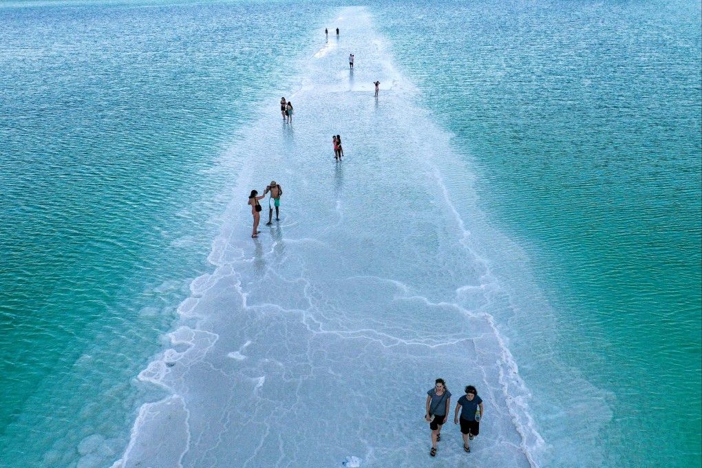 People walk on a salt strand between evaporation ponds in the southern part of the Dead Sea in 2021. Due to its location in the desert and scarcity of natural resources, Israel has been a living laboratory for the development of climate solutions. Photo: AFP