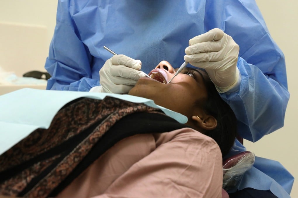 A dentist attends to a patient at the Prince Philip Dental Hospital in Sai Ying Pun in 2020. Photo: K.Y. Cheng