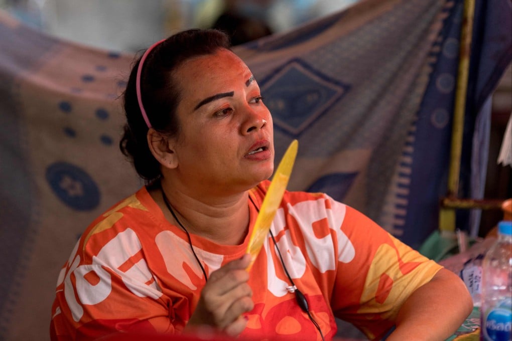 A street food vendor fans herself at her stall during heatwave conditions in Bangkok. Photo: AFP