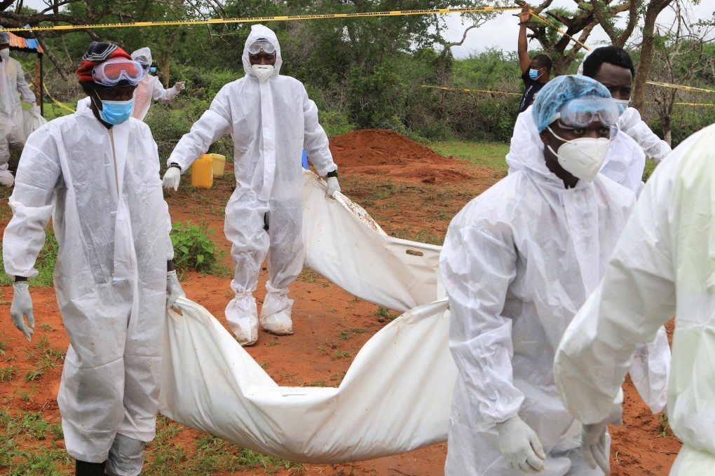 Forensic experts and police carry the bodies of suspected members of a cult after their remains were exhumed from their graves in Shakahola forest, Kilifi county, Kenya on Saturday. Photo: Reuters