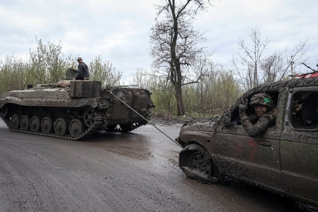 Ukrainian soldiers pull a damaged car by a BMP-1 infantry fighting vehicle in the town of Chasiv Yar, near a front line in Donetsk region, Ukraine on Saturday. Photo: Reuters