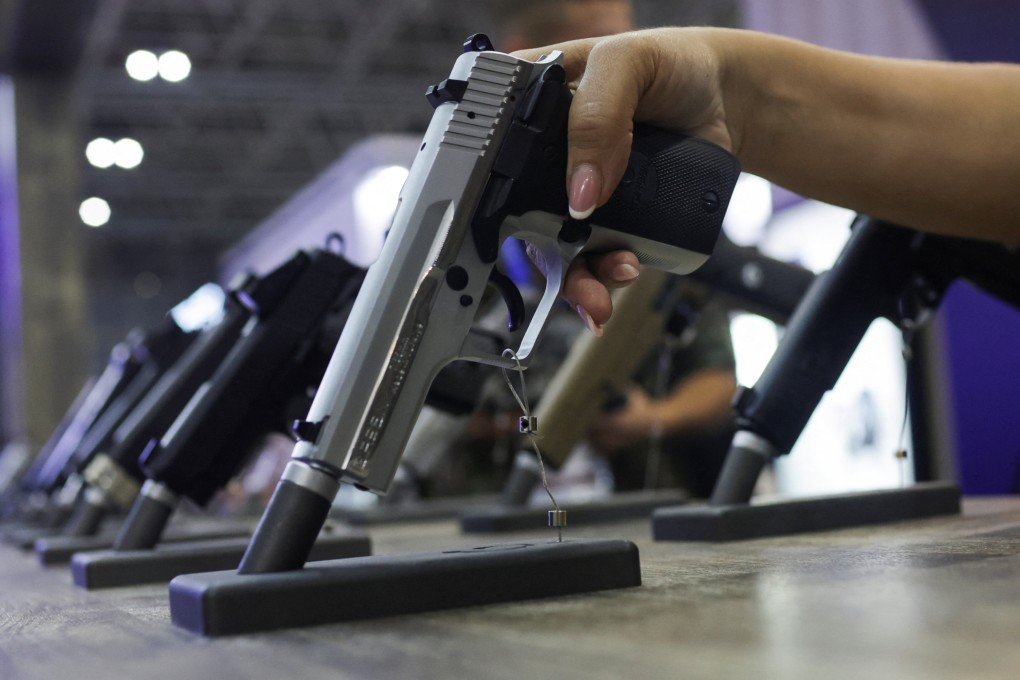 A woman holds a gun during a military industry event in Brazil on April 11. Attacks in schools there are rising. Photo: Photo: Reuters