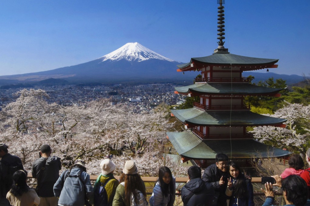 Tourists gather at a popular scenic spot where Mount Fuji and cherry blossoms can be seen together. Fewer Japanese are opting to take holidays abroad than before the pandemic. Photo: Kyodo