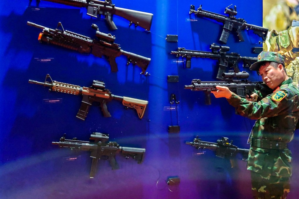 A Vietnamese officer tries a weapon at the stalls  of Czech security firms at the Vietnam International Defence Expo 2022 in Hanoi in December. Photo: Reuters