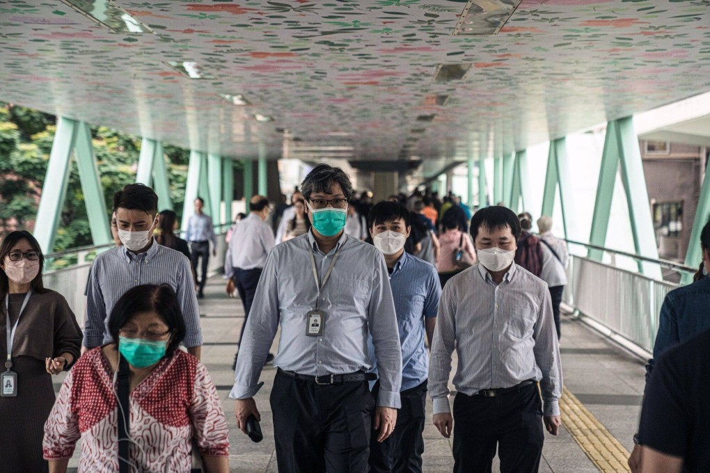 Pedestrians on a footbridge in Hong Kong. A survey in the city found that men and property owners are more likely to use fintech services. Photo: Bloomberg