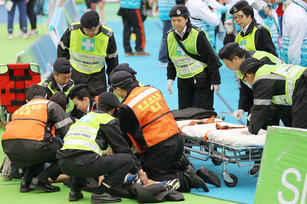 Auxiliary Medical Service volunteers look after a runner who collapsed during a marathon. Photo: Nora Tam