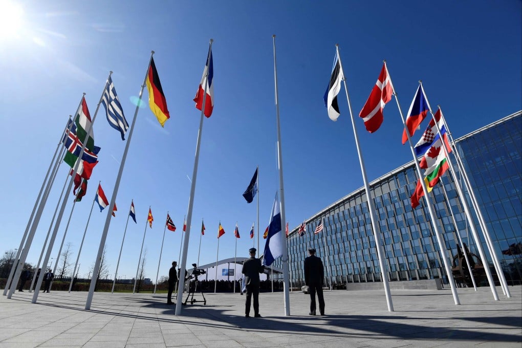 Finnish military personnel install the Finnish national flag at the NATO headquarters in Brussels, on April 4, 2023. Photo: AFP
