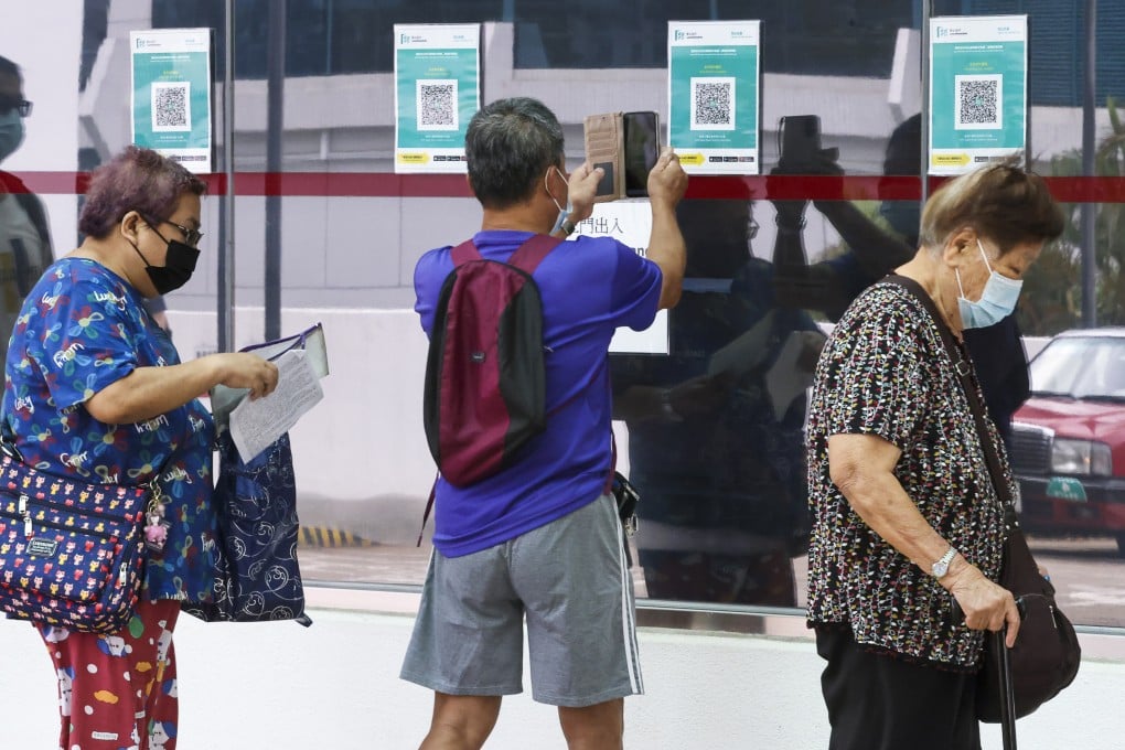 A man scans the QR code for the Covid-19 vaccine arrangements, at the Hong Kong Eye Hospital in Kowloon City, on June 13, 2022. Photo: K. Y. Cheng