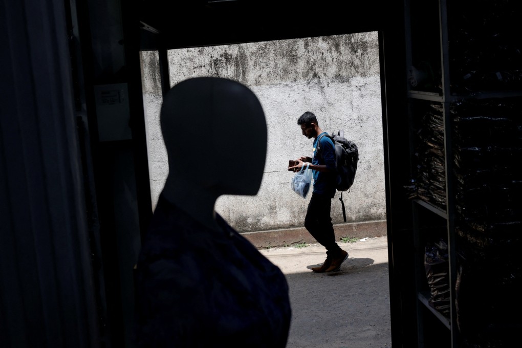 A man walks past a wholesale clothes shop while checking his wallet in Colombo, Sri Lanka, on April 11. Sri Lanka is geopolitically more relevant to China than many other debt-ridden countries. Photo: Reuters