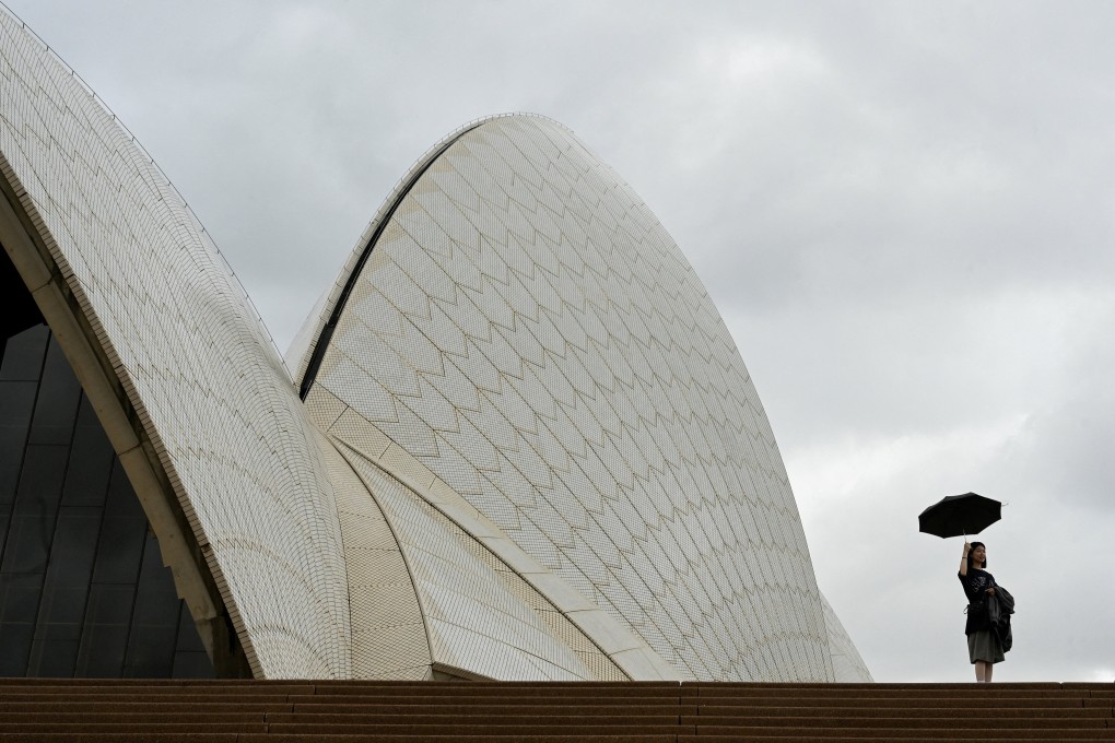 A woman holds an umbrella at the Sydney Opera House. If Canberra wants people to be transparent, they too must be transparent otherwise all they do is strike fear in the hearts and minds of people. Photo: Reuters