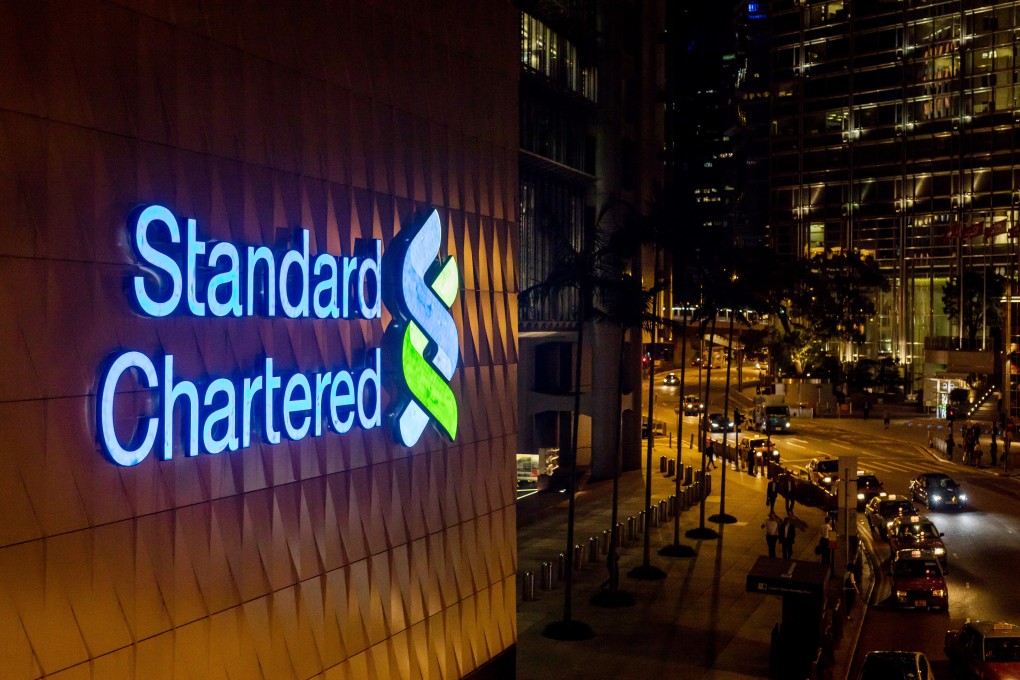 Signage is illuminated atop a Standard Chartered bank branch in Hong Kong. Photo: Bloomberg