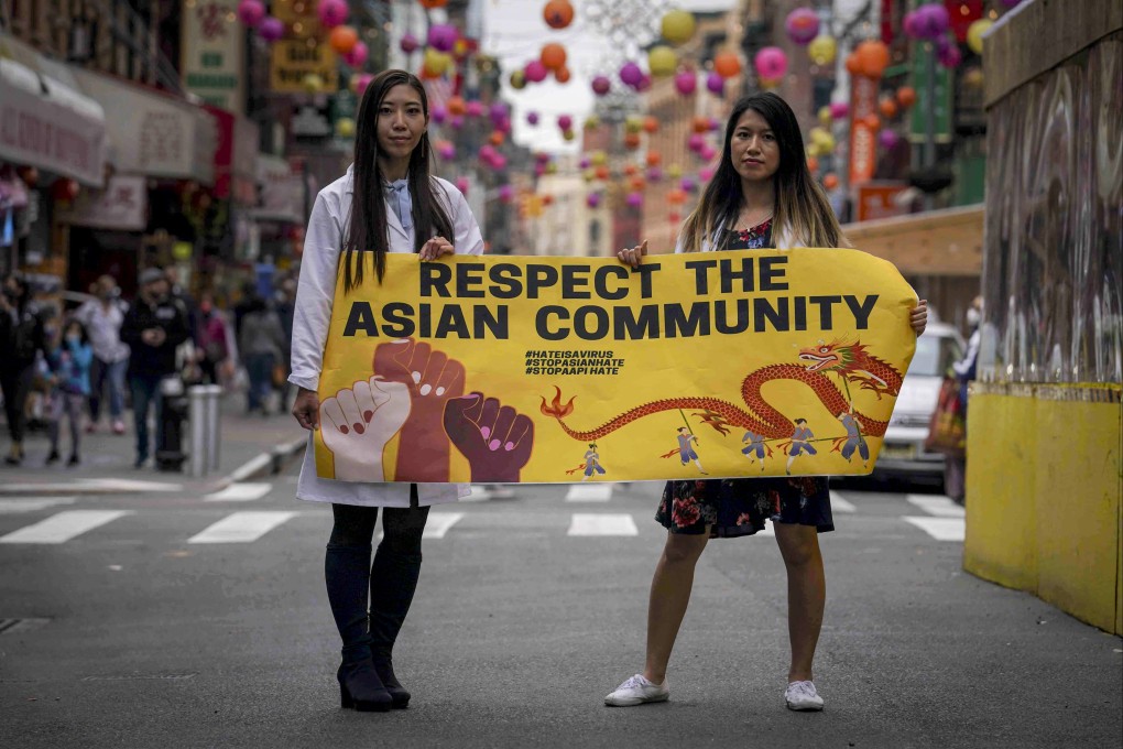 Michelle Lee (left) and Ida Chen hold a banner in New York’s Chinatown to protest anti-Asian hate in April 2021. Photo: AP