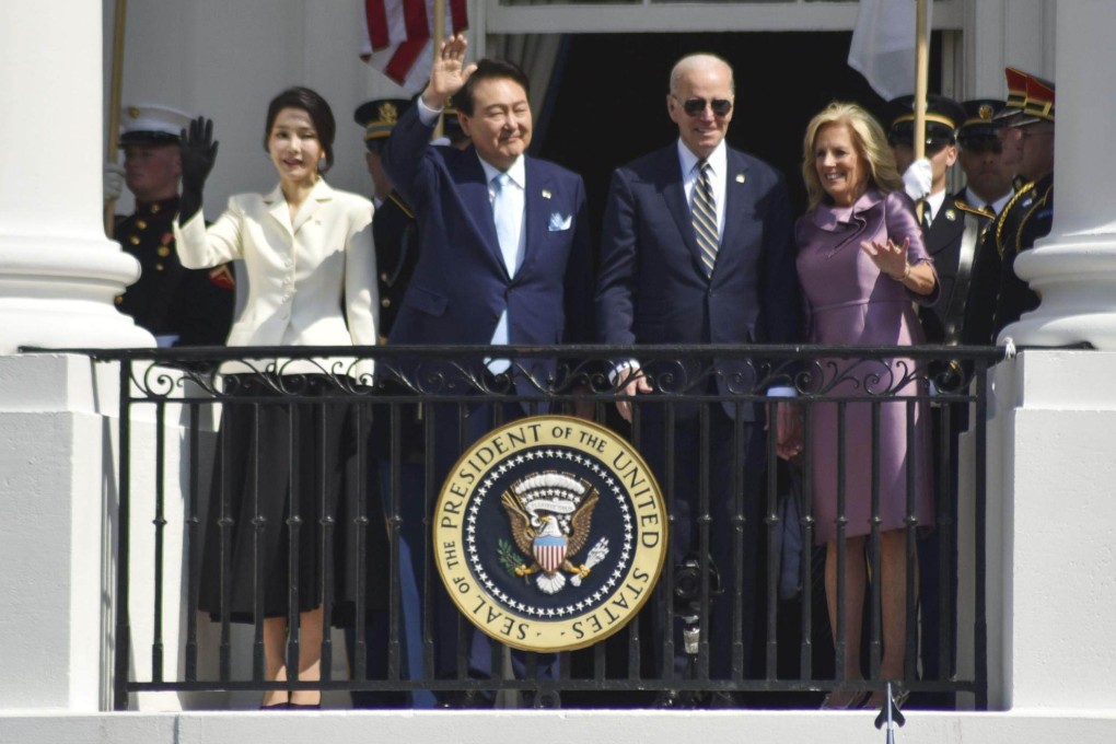 US President Joe Biden, South Korean President Yoon Suk Yeol, and their wives wave from a White House balcony on April 26. Photo: Kyodo