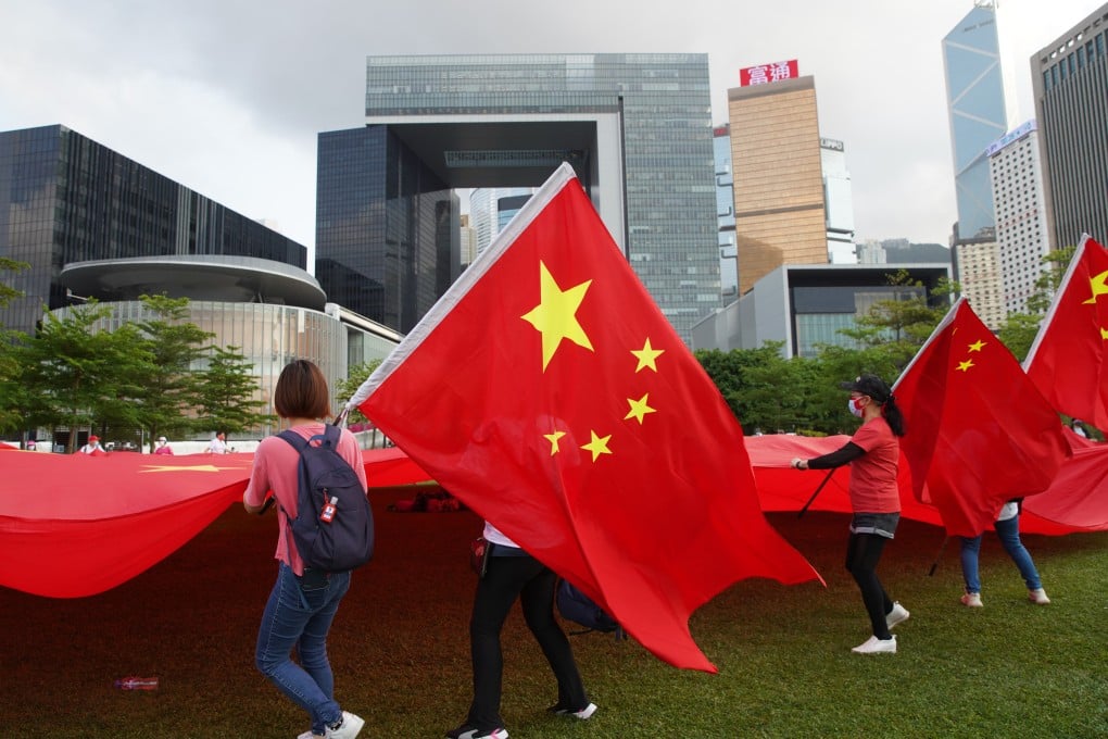 Supporters of reform for Hong Kong’s electoral system hold up the national flag at a demonstration in Tamar Park on March 30, 2021. The overdue reform of the district councils will ensure they are in good hands. Photo: Winson Wong