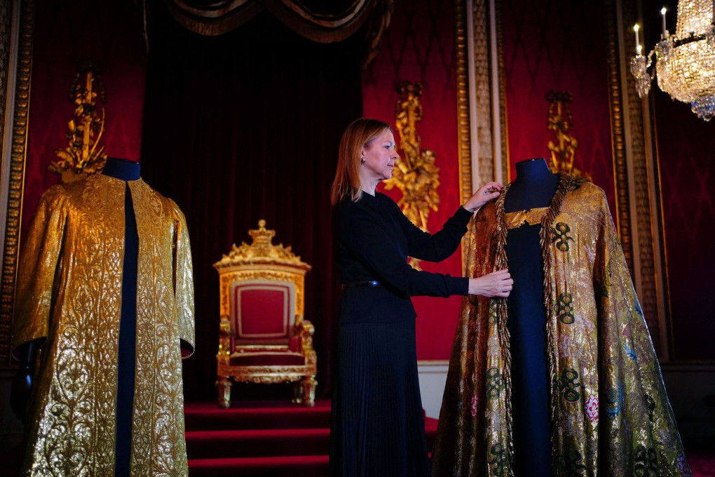 Caroline de Guitaut, Deputy Surveyor of the King’s Works of Art for the Royal Collection Trust, adjusts the Imperial Mantle in the Throne Room at Buckingham Palace on Wednesday. Photo: AFP