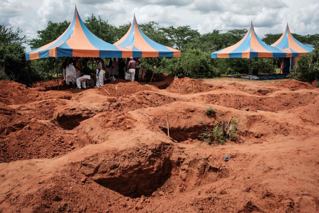 Workers take shelter while digging the ground to exume bodies from the mass-grave site in Shakahola. Photo: AFP