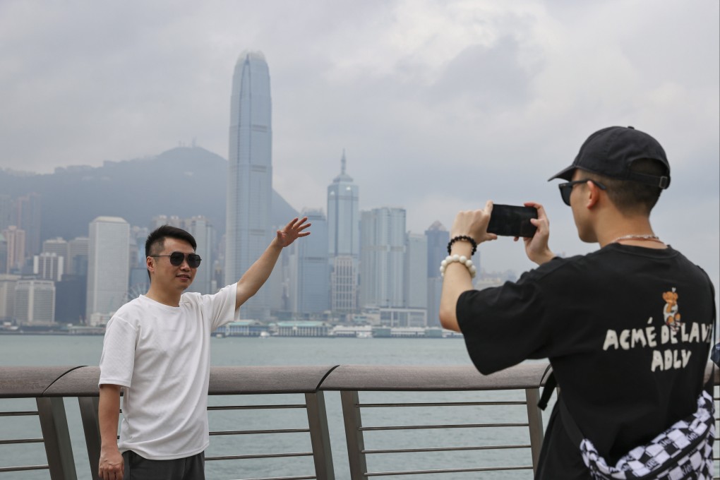 Mainland tourists Zeng Hui (left) and Chen Jiayi follow a trend on Xiaohongshu of recreating a well-known photo of Hong Kong billionaire Li Ka-shing. Photo: May Tse