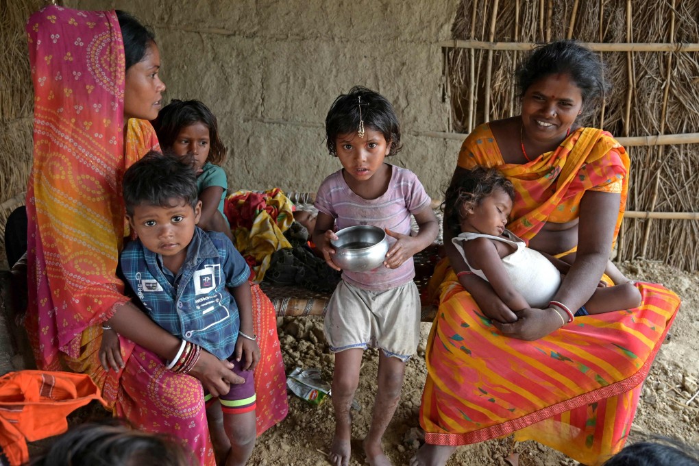 Village women Kavita Devi (L) and Savita Devi pose with their children at their house in Darbhanga district of India’s Bihar state. Photo: AFP