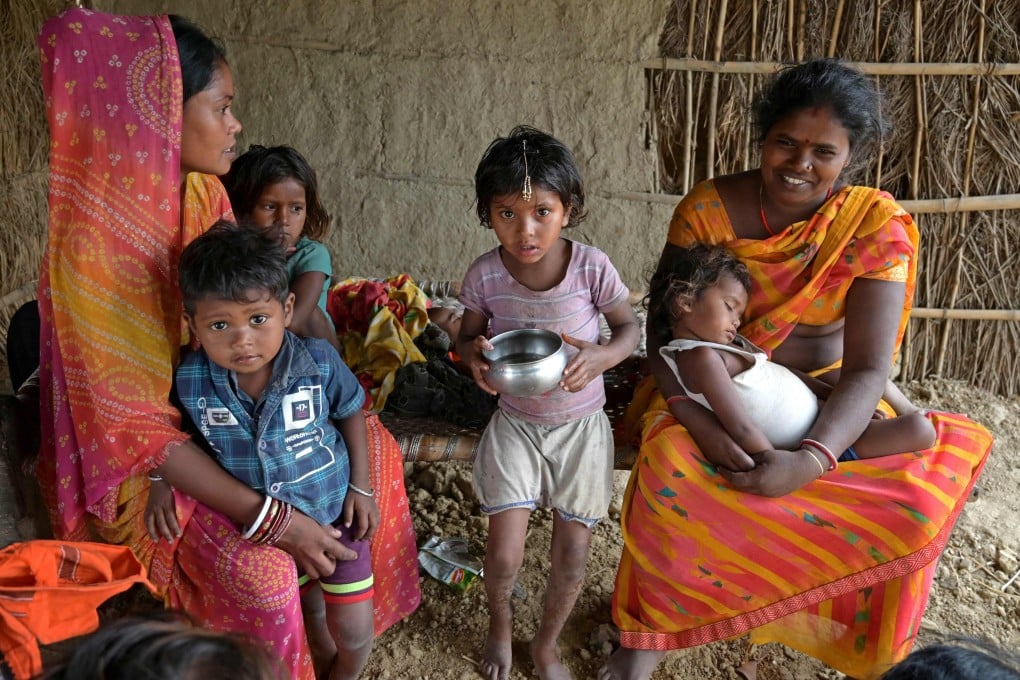 Village women Kavita Devi (L) and Savita Devi pose with their children at their house in Darbhanga district of India’s Bihar state. Photo: AFP